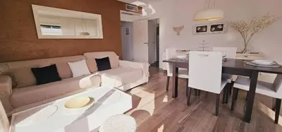 a living room with a couch and a dining room at Ideal for families on the beach in Barcelona with a pool in Badalona