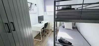 a dorm room with a bunk bed and a desk at Ideal for families on the beach in Barcelona with a pool in Badalona