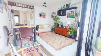 a living room with a table and a bedroom at Cosy flat in pretty seaside town in Sitges