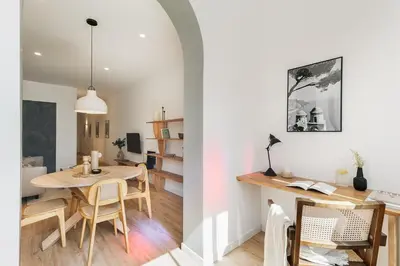 a room with windows and a desk and a table at Faro - 2 bedroom in Eixample Esquerra in Barcelona