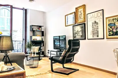 a living room with a chair and pictures on the wall at La Rambla spacious 3BR monthly rental - Parsifal in Barcelona