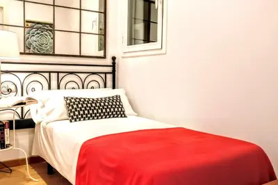a bedroom with a bed with a red blanket on it at La Rambla spacious 3BR monthly rental - Parsifal in Barcelona
