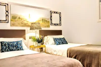 a room with two beds and a table with flowers at La Rambla spacious 3BR monthly rental - Parsifal in Barcelona
