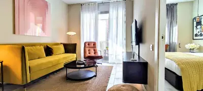 a living room with a yellow couch and a bed at Relaxing 3BR w terrace in heart of Gràcia - Bossa in Barcelona