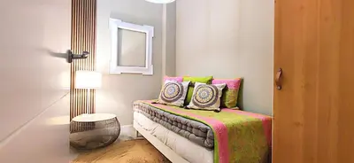 a room with a bed with pillows and a mirror at Relaxing 3BR w terrace in heart of Gràcia - Bossa in Barcelona