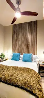 a bedroom with a ceiling fan and a bed with blue pillows at Relaxing 3BR w terrace in heart of Gràcia - Bossa in Barcelona