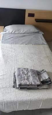 a white bed with a blanket on top of it at Habitación en piso compartido in Terrassa