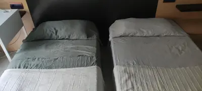 two beds sitting next to each other in a room at Habitación en piso compartido in Terrassa