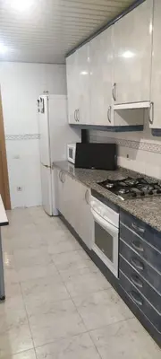 a kitchen with a stove and a refrigerator at Habitación en piso compartido in Terrassa