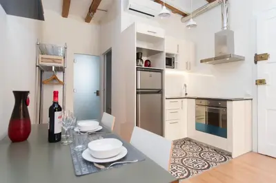a kitchen with a table with plates and a bottle of wine at Apartments Barcelona Sagrada in Barcelona