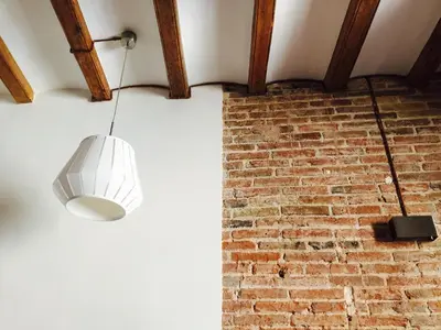 a light fixture hanging from a brick wall at Apartments Barcelona Sagrada in Barcelona