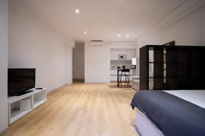 a bedroom with a bed and a flat screen tv at Bcn - Loft Parc Guell in Barcelona