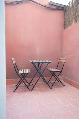 two chairs and a table in front of a wall at Bcn - Loft Parc Guell in Barcelona