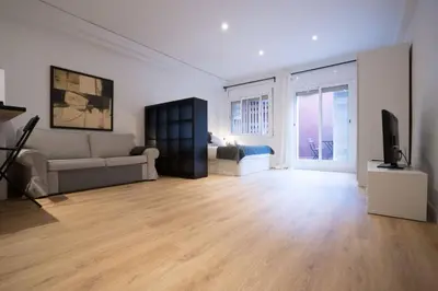 a living room with a couch and a television at Bcn - Loft Parc Guell in Barcelona