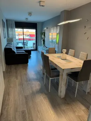 a dining room with a wooden table and chairs at Atico espectacular Cunit in Cunit