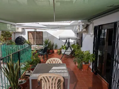 an outdoor patio with a table and chairs and umbrellas at Apartamento Barcelona in Hospitalet de Llobregat