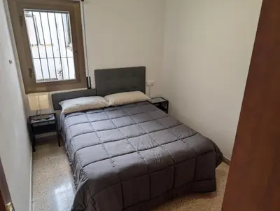 a bedroom with a bed in a room with a window at Apartamento Barcelona in Hospitalet de Llobregat