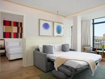 a bedroom with a bed and a couch and a room at H10 Cubik 4* Sup in Barcelona