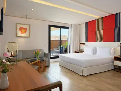 a bedroom with a bed and a living room at H10 Cubik 4* Sup in Barcelona
