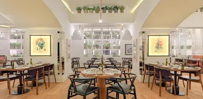 a restaurant with wooden tables and chairs and windows at H10 Cubik 4* Sup in Barcelona