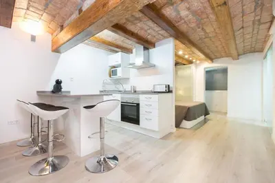 a kitchen with a counter and stools in a room at Apartamento Barcelona playa in Barcelona