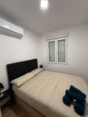 a bedroom with a bed with blue pillows on it at Modern apartment 2 Barcelona in Santa Coloma de Gramanet