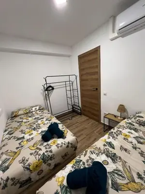 a bedroom with two beds and a door at Modern apartment 2 Barcelona in Santa Coloma de Gramanet