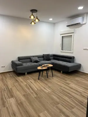a living room with a black couch and a table at Modern apartment 2 Barcelona in Santa Coloma de Gramanet