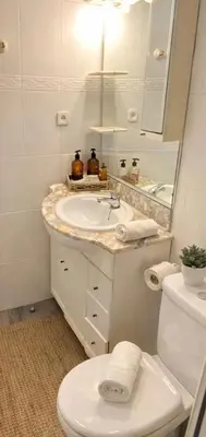 a bathroom with a sink and a toilet and a mirror at Atlantida House Self Check-in in Hospitalet de Llobregat