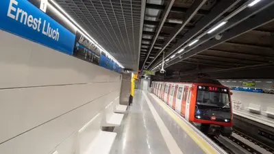 a red train is pulling into a subway station at Atlantida House Self Check-in in Hospitalet de Llobregat