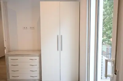 a white closet with a dresser and a window at Homenfun Barcelona Camp Nou in Hospitalet de Llobregat