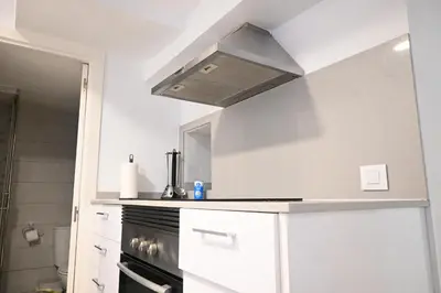a kitchen with white cabinets and a stove top oven at Homenfun Barcelona Camp Nou in Hospitalet de Llobregat