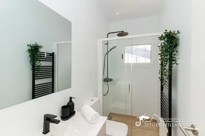a kitchen with a wooden door and a refrigerator at Sunny Villa Moments near Sitges in Olivella