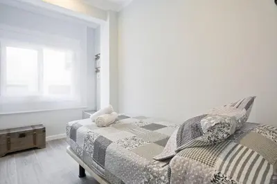 a white bedroom with a bed and a window at Stay U-nique Apartments Llobregat in Hospitalet de Llobregat