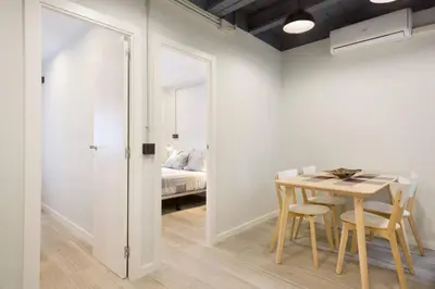 a room with a table and chairs and a bed at Stay U-nique Apartments Llobregat in Hospitalet de Llobregat