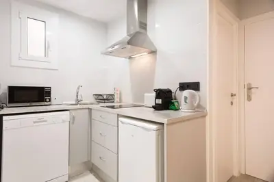 a white kitchen with a sink and a microwave at Stay U-nique Apartments Llobregat in Hospitalet de Llobregat