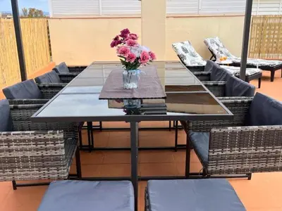 a table and chairs with a vase of flowers on it at Apartment Sunset in Cunit