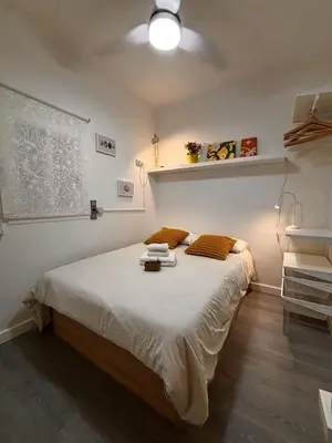 a bedroom with a bed with white sheets and orange pillows at Full flat in the heart of Barcelona in Barcelona