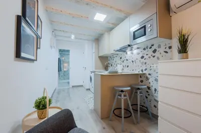a kitchen with a counter and stools in a room at Acogedor y céntrico Estudio 1 in Barcelona