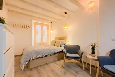 a bedroom with a bed and a chair and a window at Acogedor y céntrico Estudio 2 in Barcelona