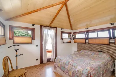 a bedroom with a bed in a room with windows at Casa con piscina salina a 5 minutos de Sitges in Canyelles