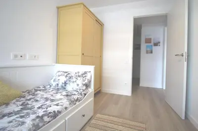a bedroom with a bed and a dresser in it at Rooftop pool near the beach and Barcelona in Masnou