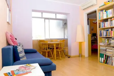 a living room with a blue couch and a table at 3rooms, 10 minAirport, free parking, public transp in Cornellà de Llobregat
