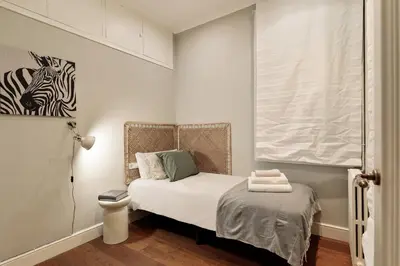 a small bedroom with a bed and a zebra picture on the wall at Enjoy Apartments Augustina's Grand Family Suite in Barcelona