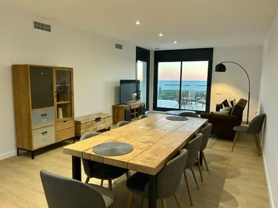 a living room with a wooden table and chairs at Les Flors de Cunit Villa Edelweiss in Cunit