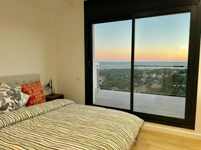 a bedroom with a bed and a large window at Les Flors de Cunit Villa Edelweiss in Cunit