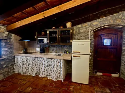 a kitchen with an old refrigerator in a room at Mas del Drac in Castellví de la Marca