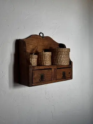 a wooden shelf with wicker baskets on a wall at Mas del Drac in Castellví de la Marca