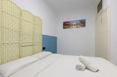 a bedroom with a white bed and a wall at matarolux21 in Mataró