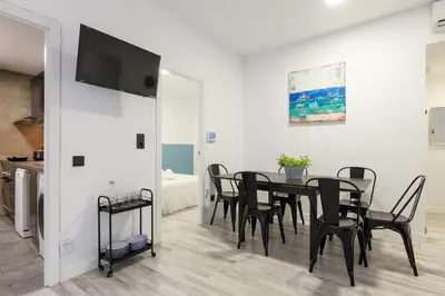 a dining room with a black table and chairs at matarolux21 in Mataró